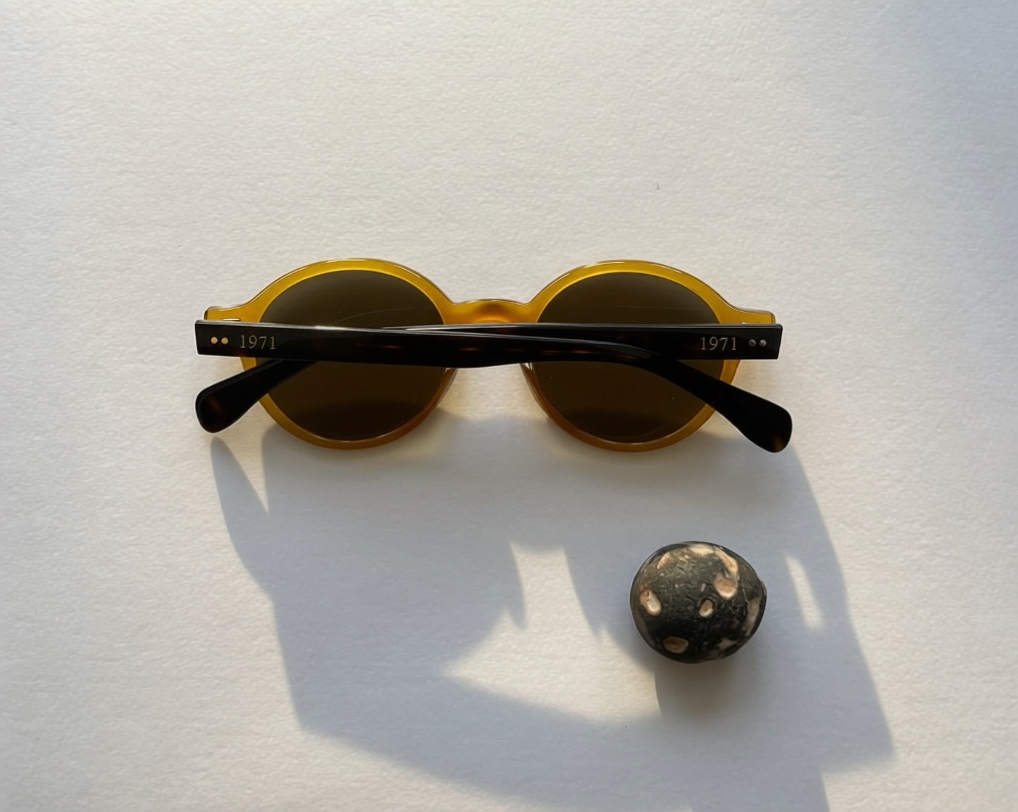 Vintage-inspired round sunglasses with translucent amber frames and dark lenses from the 1971 eyewear collection.