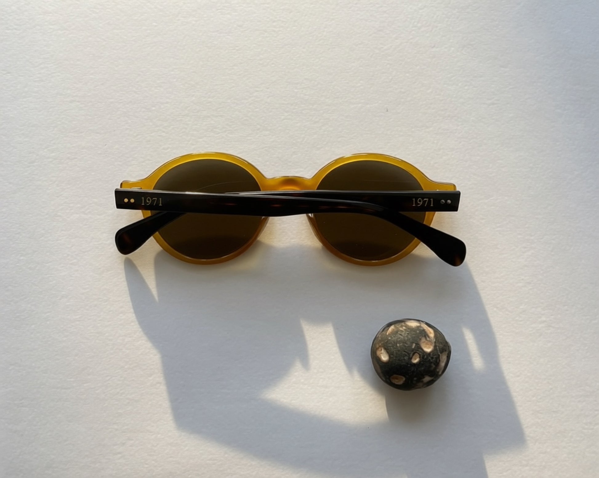 Vintage-inspired round sunglasses with translucent amber frames and dark lenses from the 1971 eyewear collection.